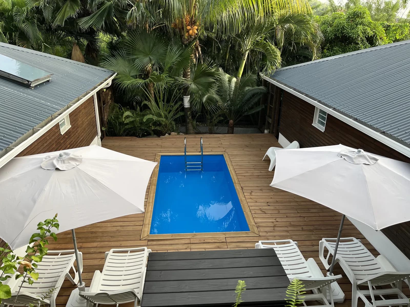 Piscine entre les lodges Manguier et Papayer, parasols et transats au soleil