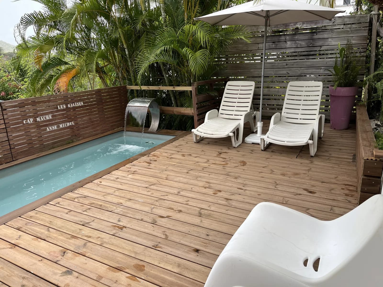 Private pool of Palmier, sun loungers and parasol on the wooden deck